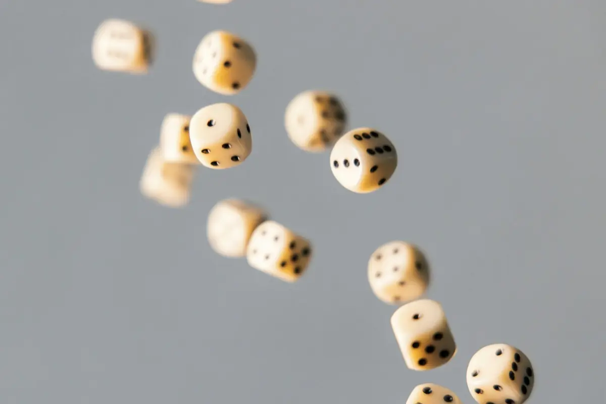 Ivory dice against a grey background representing random selection