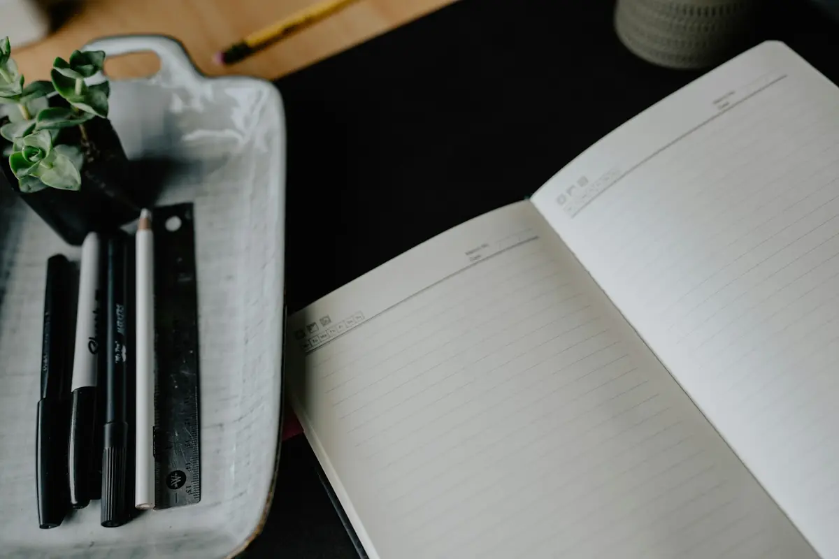 An open notebook and pens for preparing simple learning cards